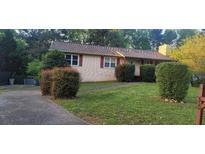 Ranch style home with reddish-brown siding and landscaping at 650 Lowell Sw Dr, Marietta, GA 30008