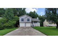 Charming two-story house with a double garage and well-maintained lawn at 6050 April Dr, Sugar Hill, GA 30518