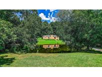 Ranch home nestled on a wooded lot with a pond reflection at 3409 Camp Branch Rd, Buford, GA 30519