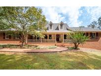 Brick house with a large front porch and walkway at 1827 Lost Mountain Rd, Powder Springs, GA 30127