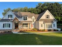 Two-story farmhouse features white exterior, stone accents, and a covered porch at Lot 2 Thunder Rd, Buford, GA 30518