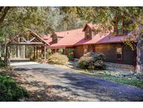 Log home with red metal roof and covered entryway at 1785 Whitley Rd, Dacula, GA 30019