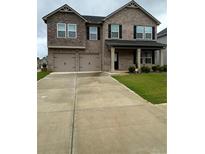 Two-story brick home with two car garage and landscaping at 163 Kingfisher Walk, Covington, GA 30014