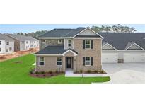 Two-story brick home with attached garage and manicured lawn at 600 Silver Moon Dr # 08, Loganville, GA 30052