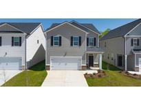 Two-story home with gray siding, black shutters, and a two-car garage at 11964 Conrad Cir, Hampton, GA 30228