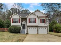 Charming two-story home with a two-car garage and landscaped front yard at 76 Cedars Glen Cir, Villa Rica, GA 30180