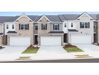 New townhome community with three-story townhouses, two-car garages, and landscaping at 2711 Honey Locust Ct # 64, Loganville, GA 30052