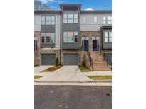 Modern three-story townhome with gray and brick exterior, two-car garage, and a staircase at 2174 Avion Way # 11, Chamblee, GA 30341