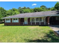 Brick ranch house with a carport and lawn at 3321 S Norcross Tucker Rd, Tucker, GA 30084