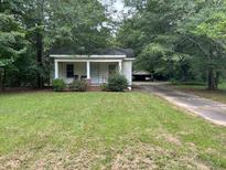 Small cottage style home with front porch and detached garage at 2154 Brockett Rd, Tucker, GA 30084