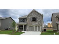 Two-story home with brick exterior and a three-car garage at 953 Ulster Ct, Loganville, GA 30052