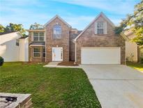 Two-story brick home with a large yard and attached garage at 3863 Micah Ln, Ellenwood, GA 30294