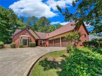 Brick house with three-car garage and landscaped yard at 421 Thornbush Trce, Lawrenceville, GA 30046