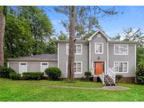 Two-story house with gray siding, a brick foundation, and a landscaped yard at 2848 Creekwood Dr, Snellville, GA 30078