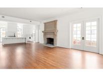 Spacious living room featuring hardwood floors, a large fireplace, and French doors at 1585 S Ponce De Leon Ave # M1, Atlanta, GA 30307