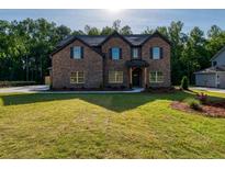 Brick two-story house with a covered front porch and landscaping at 557 Saltbox Ln, Mcdonough, GA 30252