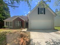 Two-toned house with attached garage and landscaped front yard at 5233 Walnut Ct, Lithonia, GA 30038