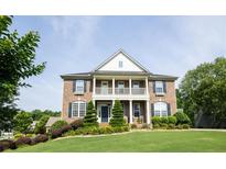 Brick two-story house with a front porch and landscaped yard at 249 Chadwyck Ln, Canton, GA 30115