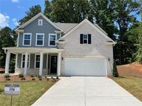 Two-story home with gray siding, white brick accents, and a three-car garage at 29 Riverbirch Ct, Dallas, GA 30157