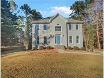 Two-story house with gray siding, blue door and stone accents, set on a grassy lot at 120 Blackberry Run, Fayetteville, GA 30214