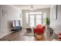 Living room with hardwood floors, a comfy sofa and large TV at 401 16Th Nw St # 1157, Atlanta, GA 30363