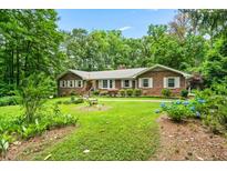 Brick ranch house with landscaped yard and walkway at 2690 Hideaway Hills Sw Ln, Powder Springs, GA 30127