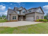 Two-story house with stone and siding accents and a three-car garage at 7019 Becca Ln, Locust Grove, GA 30248