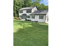 Two story house with white siding, gray roof, and landscaping at 4604 Shumart Dr, Snellville, GA 30039
