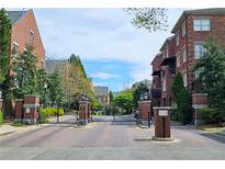 Brick gated community entrance with landscaping and street view at 1735 Peachtree Ne St # 210, Atlanta, GA 30309