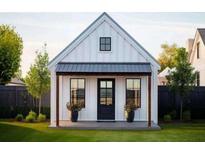 Charming farmhouse-style home with a black metal roof and white siding at 24 Cheney St, East Point, GA 30344