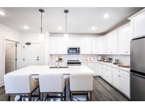 Modern white kitchen with island, stainless steel appliances, and quartz countertops at 3351 Orwell Way # 2104, Cumming, GA 30041