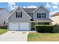 Two-story house with gray siding, two-car garage, and manicured lawn at 5908 Bluegrass Vw, Fairburn, GA 30213