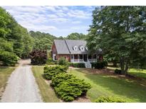 Brick home with a large wrap-around porch and expansive yard at 3651 Chandler Haulk Rd, Loganville, GA 30052