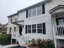 Two-story townhome with white siding, black windows, and a front porch at 611 Sweet Bay Rdg, Woodstock, GA 30188