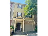 Tan two-story townhome with brown shutters and a two-car garage at 3658 Utoy Sw Dr, Atlanta, GA 30331