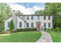 Two-story brick home with landscaped yard and red door at 303 Walnutwood Trl, Roswell, GA 30075