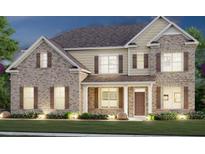 Two story home exterior at night, featuring brick and siding accents, and a welcoming front porch at 255 Arwen Dr, Mcdonough, GA 30252