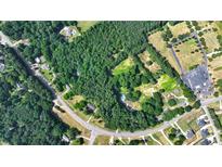 Aerial view showing a large lot with surrounding trees and nearby houses at 3525 Hamilton Mill Rd, Buford, GA 30519