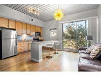 Open concept kitchen with granite countertop, light wood cabinets, and breakfast bar at 620 Glen Iris Ne Dr # 205, Atlanta, GA 30308