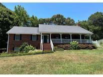 Brick ranch home with covered porch and landscaping at 410 Kilcrease Rd, Auburn, GA 30011