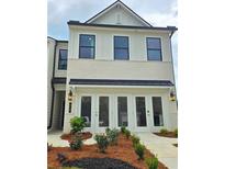 Two-story townhome with white brick exterior, double doors, landscaping at 1206 Brooks Ryan Run(Lot 102), Lawrenceville, GA 30043