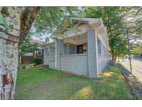 Brick home with a covered porch and well-maintained lawn at 604 Glen Iris Ne Dr, Atlanta, GA 30308