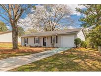 Cozy ranch home with a white exterior, black shutters, and driveway at 105 Adrian Dr, Stockbridge, GA 30281