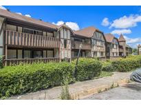 Two-story building with brown wood exterior and manicured hedges at 112 Camelot Dr, Atlanta, GA 30349