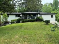 Mid-century modern ranch house featuring a freshly painted exterior and deck at 2023 Lee Dr, Austell, GA 30168