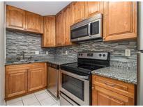 Updated kitchen features granite countertops and stainless steel appliances at 3599 Woodbriar Cir # E, Tucker, GA 30084