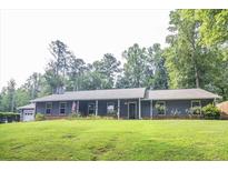 Ranch-style home with a large yard and attached garage at 1385 Ridgefield Dr, Roswell, GA 30075