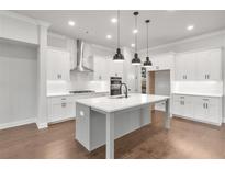 Modern kitchen with white cabinets, a large island, and stainless steel appliances at 2982 Evanshire Ave, Duluth, GA 30096