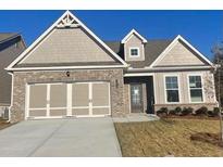 Brick and shingle two-story home with three-car garage and landscaped yard at 2414 Anhinga Dr, Loganville, GA 30052