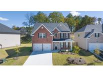 Brick two-story house with a two-car garage and landscaped yard at 1641 Lacebark Elm Way, Lawrenceville, GA 30045